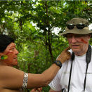 The King is painted in the face by Daví Kopenawa, the leader of the Yanomami. The red paint is obtained from the seeds of the annatto bush. (Photo: Rainforest Foundation Norway / ISA Brazil)